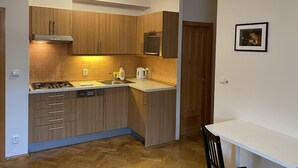 Eine kleine Küche mit Holzausstattung, einem Gasherd, einer Spüle und einer Essecke.