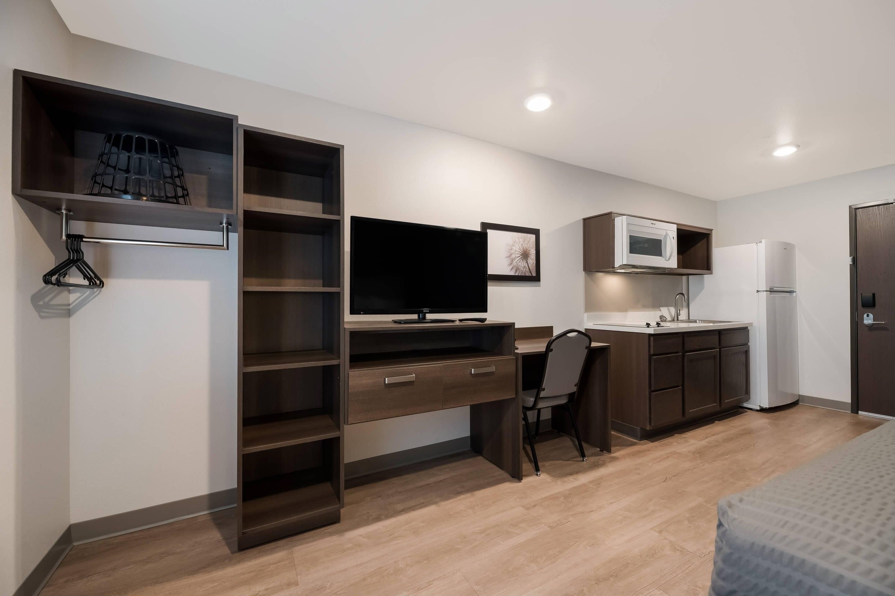 A modern kitchenette with a microwave, refrigerator, and sink.