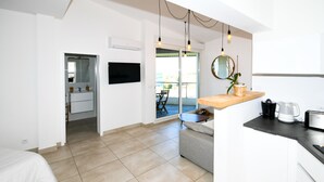 Una cocina moderna con un sofá gris, una encimera de madera y un comedor con mesa y sillas.