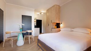 A bedroom with a bed, wooden wardrobe, and a small table with chairs. - Hyatt House Johannesburg, Sandton (Sandton)