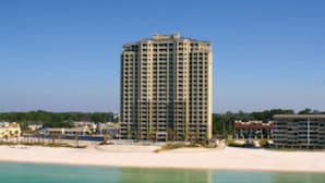 Un hôtel de grande hauteur offrant une vue sur la plage et situé près d’une étendue d’eau.