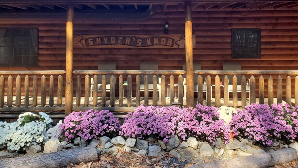 Una cabaña de madera con un cartel que dice 'SNYDER'S KNOB'.