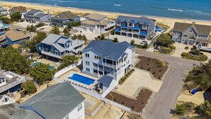 A coastal residential area with houses, a beach, and a clear sky. - Great White Shack | 120 ft to the beach | Private Pool, Hot tub (Virginia Beach)