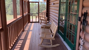 A wooden cabin with a porch, rocking chairs, and a green door. - Cowboy Cabin in the Mountains - Quiet Getaway (Aguilar)