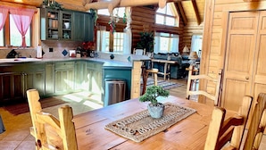 A spacious log cabin interior with a large kitchen, dining area, and a cozy living room. - Cowboy Cabin in the Mountains - Quiet Getaway (Aguilar)