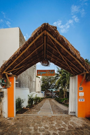 A building entrance with a thatched roof and a sign reading "Lagoon Club". - El Búho Lagoon Bacalar (Bacalar)