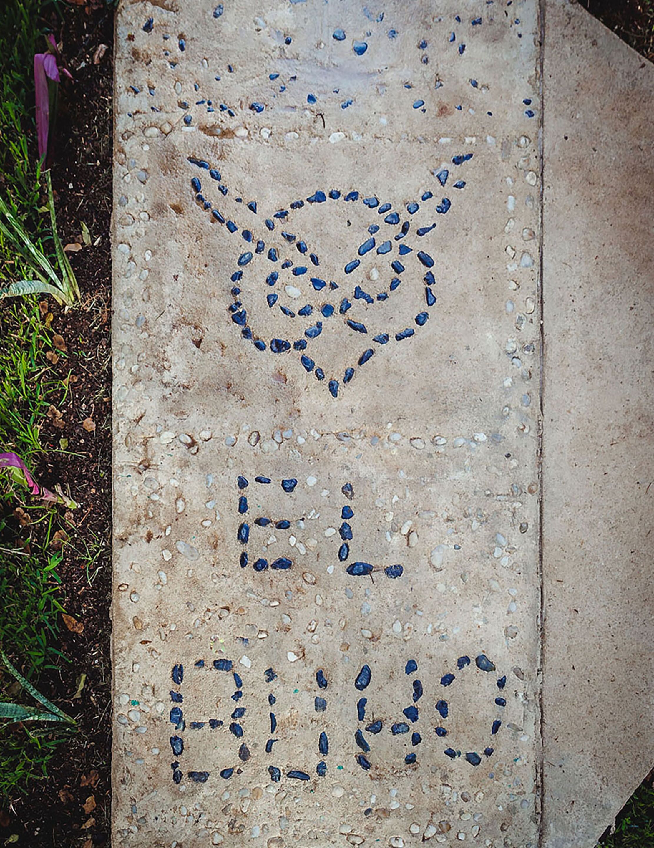 A concrete path with a heart-shaped design and the words "EL ELLO" written in blue.