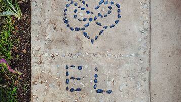 A concrete path with a heart-shaped design and the words "EL ELLO" written in blue.