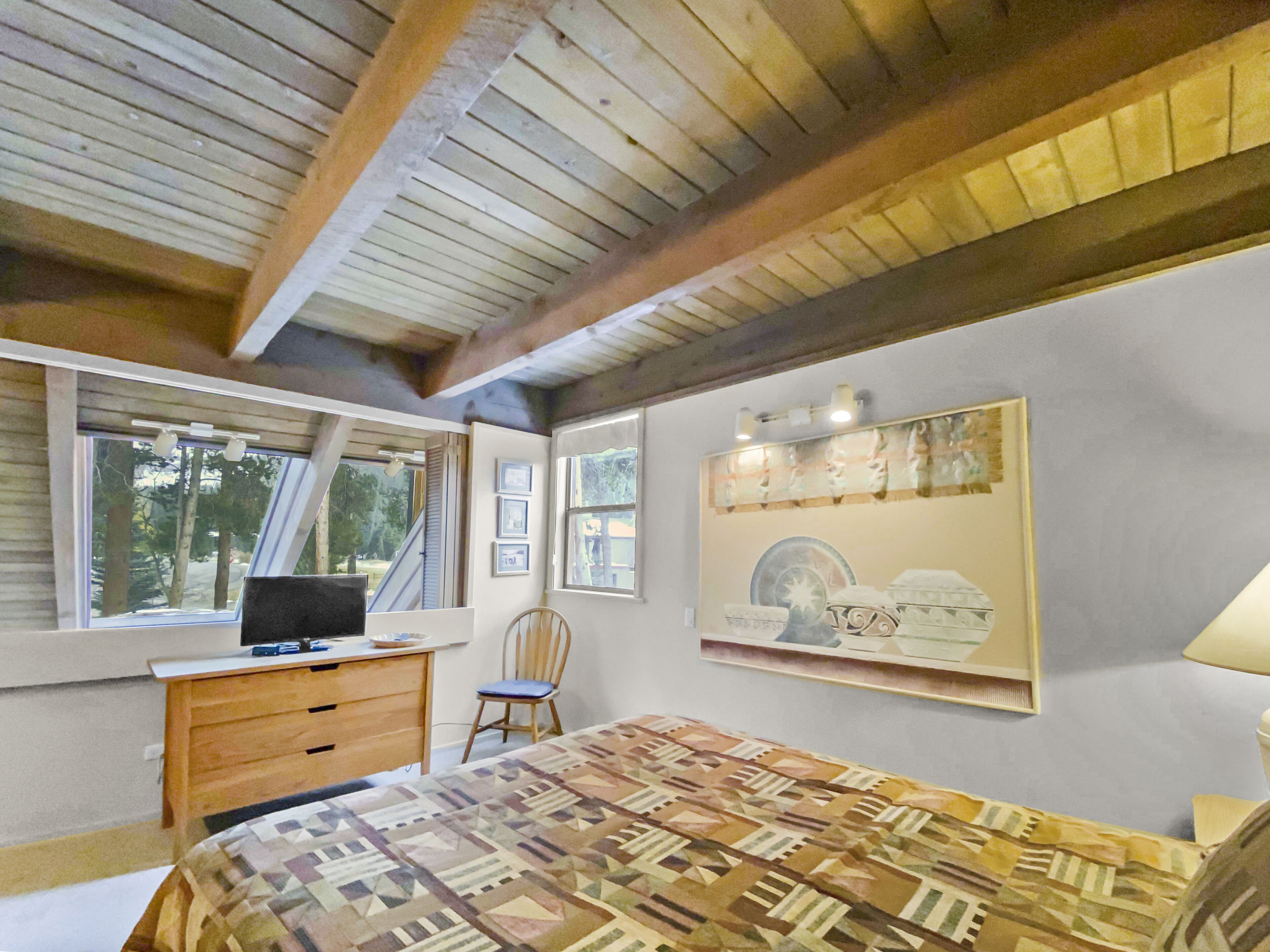 Ein Schlafzimmer mit Bett, Schreibtisch, Stuhl und Fenster.