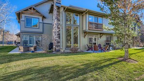 A two-story house with a large front porch, a chimney, and a well-maintained lawn. - Trade the Office for Mountains at Foxpoint Townhouse 6180 (Park City)