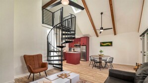 A modern loft with a spiral staircase, a kitchen, a dining area, and a living room. - 1BR + Loft Lake Chatuge Cabin w/ Mountain Views (Hiawassee)