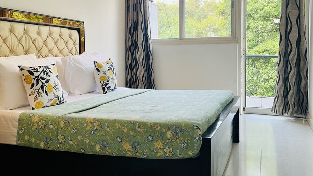 A bedroom with a bed, a window, and curtains. - BluO Modern Studio - Defence Colony Market (Delhi)