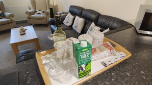 A tray with milk, tea, a wine bottle, and a glass on a kitchen counter. - The Cobbler Cottage - Loch Lomond and Arrochar Alps (Arrochar)