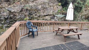 A wooden deck with a table and chairs, surrounded by a wooden railing. - The Cobbler Cottage - Loch Lomond and Arrochar Alps (Arrochar)