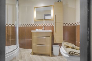 A bathroom with a shower, sink, cabinet, and toilet. - Coach House (Bridgend)