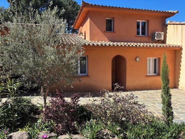 A two-story building with a tiled roof, arched entrance, and air conditioning units. - VILLA MAREA 7 PERSONS 100 M2 ALL COMFORT 3 BEDROOMS 4 MINUTES FROM THE BEACH (Sainte Lucie de Porto Vecchio)