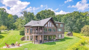 A large, multi-story log cabin with a balcony and a separate cabin attached. - Lake Access, Dock, Hot Tub, Fire Pit , Free Golf + Pickle Ball (Swanton)