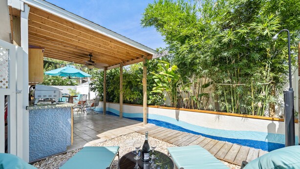 Un patio al aire libre con piscina, pérgola de madera y zona de estar.