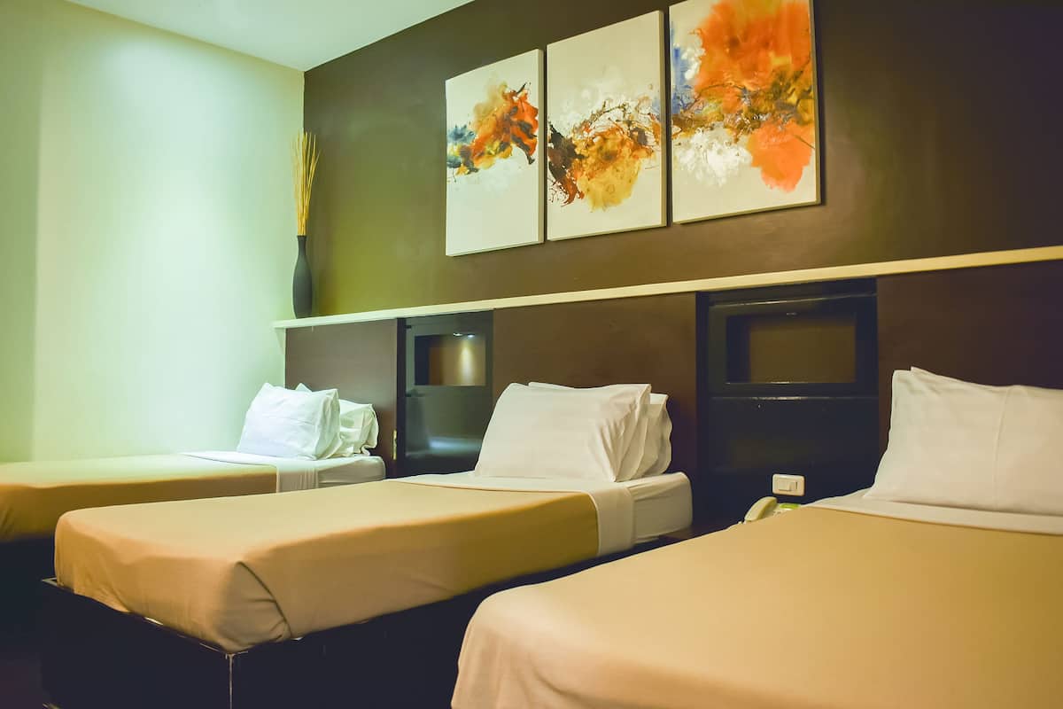 A hotel room with two beds, a wall-mounted TV, and abstract art.