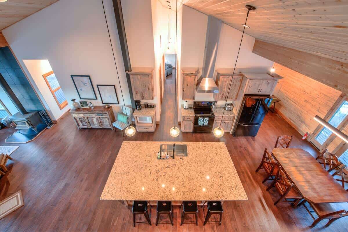 A spacious kitchen with a central island, wooden cabinets, and pendant lighting.