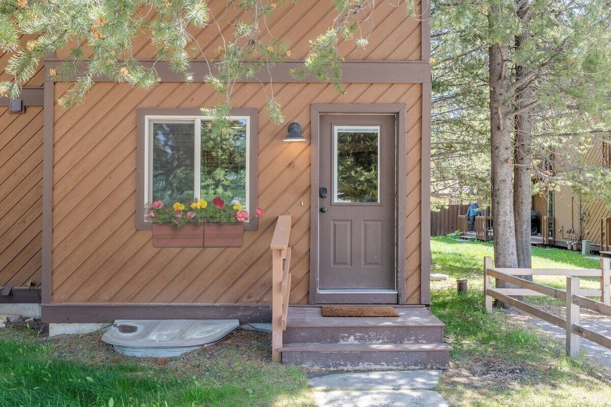 A wooden building with a door, a window, and a small porch area.
