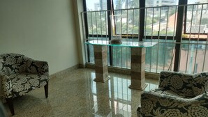 Una habitación con dos sofás estampados, una mesa con superficie de vidrio y vistas amplias a través de grandes ventanales.