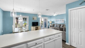 A kitchen with white cabinets, a white countertop, and pendant lights. - Cute 2/2 condo - 2 KING BEDS, Queen Sofa Sleeper and hall bunks (Destin)