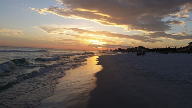 A beach with waves, a sunset, and buildings in the background. - Cute 2/2 condo - 2 KING BEDS, Queen Sofa Sleeper and hall bunks (Destin)