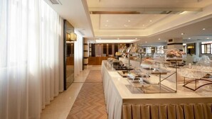 A hotel buffet area with a long counter, clear glass covers over food, and a modern interior design. - Greentree Eastern Li Lake Yuantouzhu Scenic Area Hotel (Wuxi)