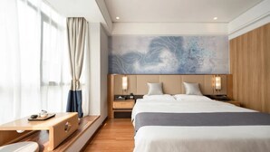 A modern hotel room with a large bed, a bedside table, a nightstand, and a wall art piece. - Greentree Eastern Li Lake Yuantouzhu Scenic Area Hotel (Wuxi)
