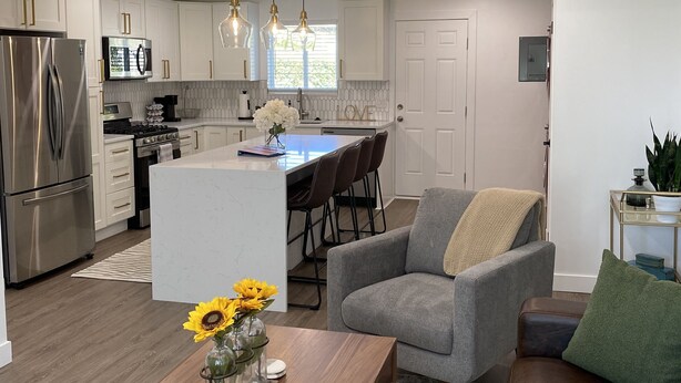 A modern kitchen with white cabinets, stainless steel appliances, and pendant lighting. - Beautiful 2 Bedroom Home In SLC with Private Hot Tub!  (Salt Lake City)