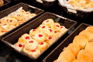 Un buffet proposant une variété de produits de boulangerie, notamment des pâtisseries et des petits pains.