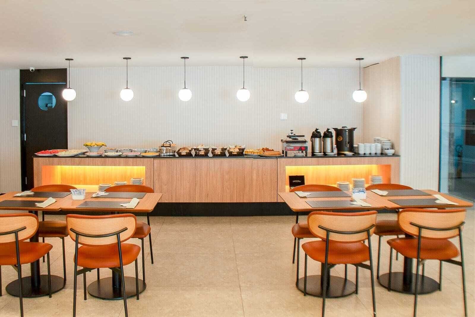 A modern dining area with a central island counter, multiple tables, and chairs.