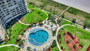 An aerial view of a hotel with a central swimming pool, landscaped gardens, and a parking area. - South Seas Tower 2-603 (Marco Island)