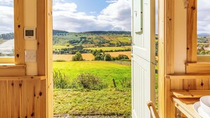 A wooden cabin with a view of rolling hills and a clear sky. - Woodside Hut 3 - UK36107 (Strathpeffer)