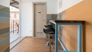 A modern hallway with a wooden door labeled "PRIVATE," a blue and orange tiled wall, and a bar stool. - Polesana Rooms (Pula)