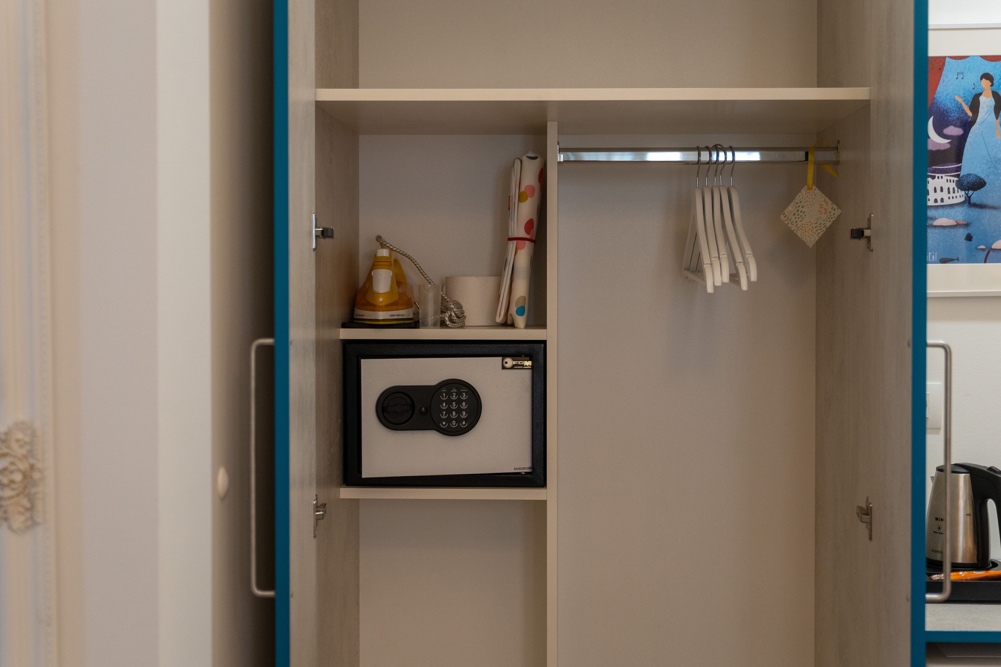 Habitación con caja fuerte integrada, hervidor de agua y tendedero.