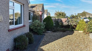 A residential area with houses, a gravel driveway, and a wind turbine in the background. - 2 bedroom accommodation in Morecambe (Morecambe)