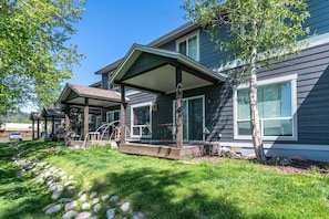 A two-story house with a covered porch, a garage, and a well-maintained lawn.