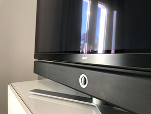 Enjoy entertainment with a flat-screen television and a minimalist stand.