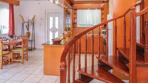 Un interior de madera con comedor, cocina y escalera.