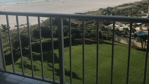 Un balcó amb vista a una platja i una zona verda.
