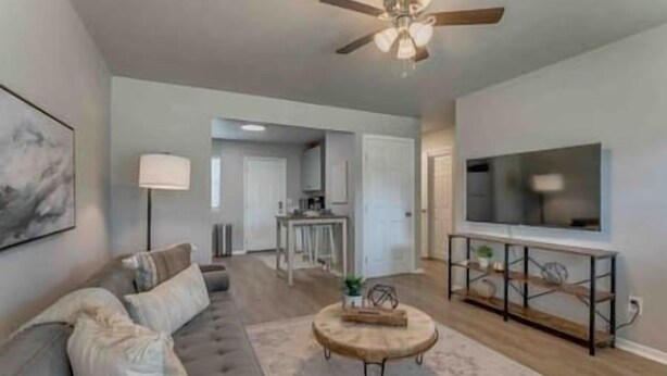 A modern living room with a sofa, coffee table, and TV stand. - 2-Bedroom Cottage w/ KING bed (Edmond)