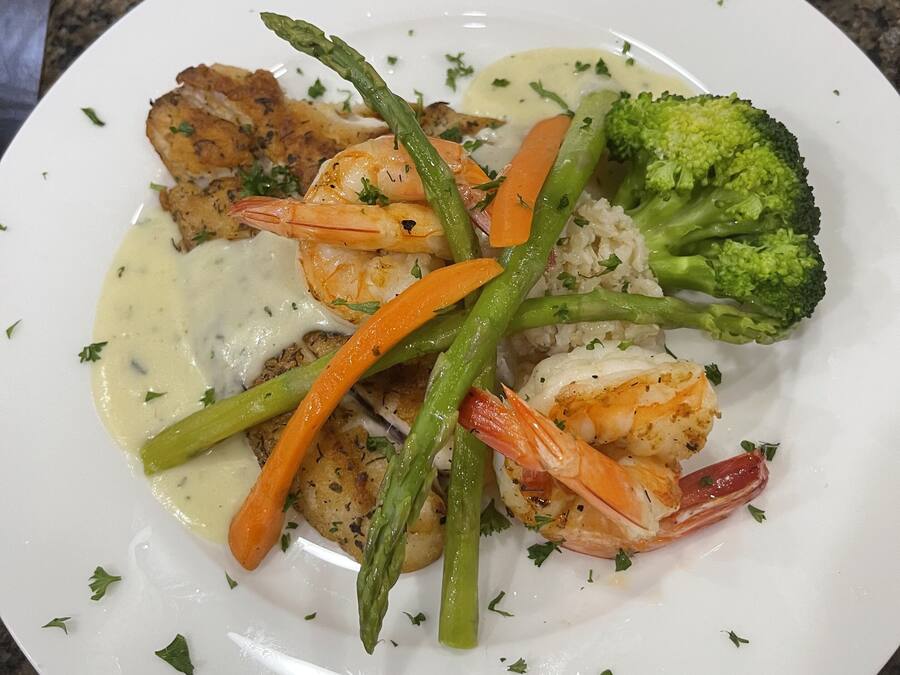 A plate of food with shrimp, asparagus, carrots, and broccoli.