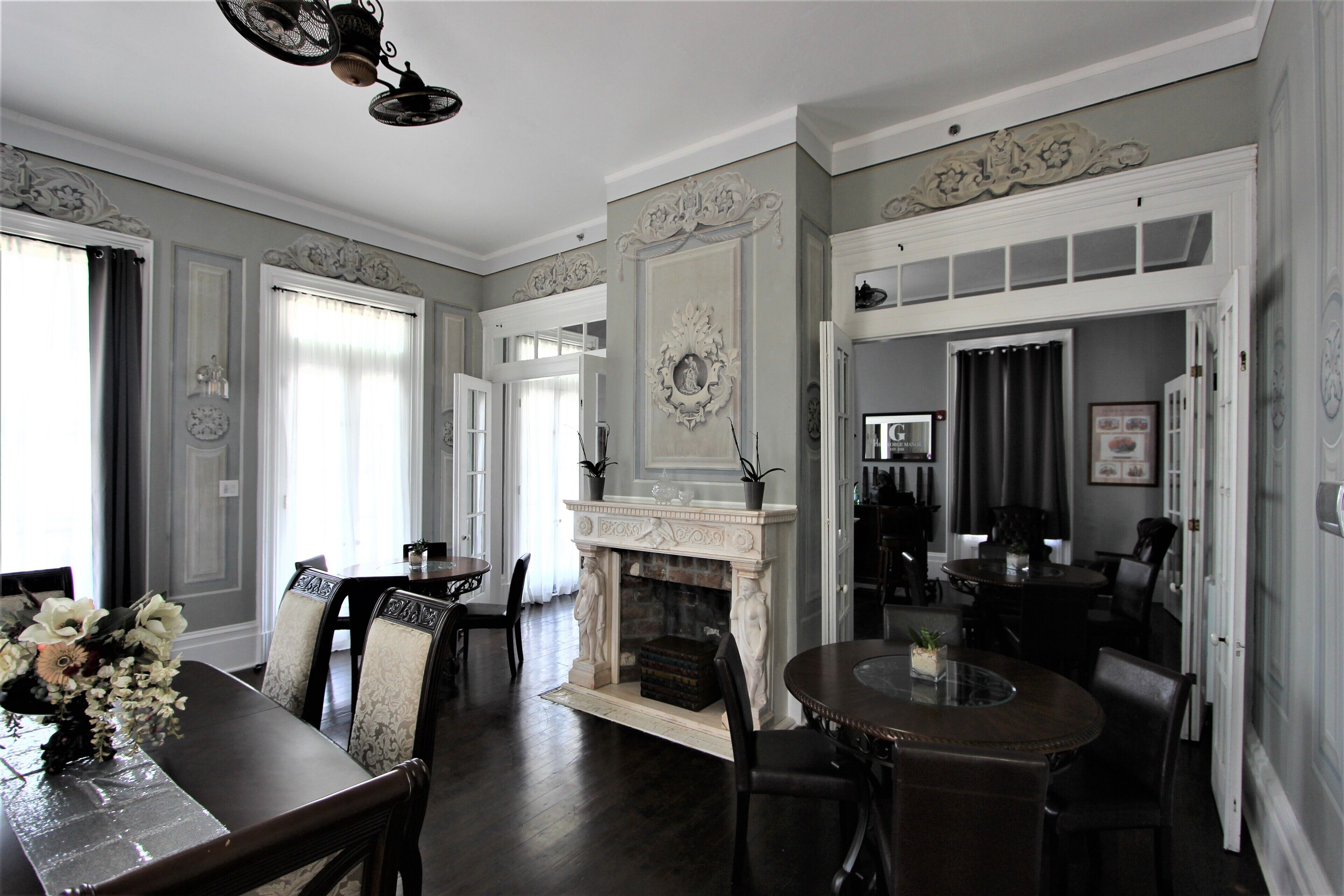 A dining room with a fireplace, a chandelier, and a dining table with chairs.