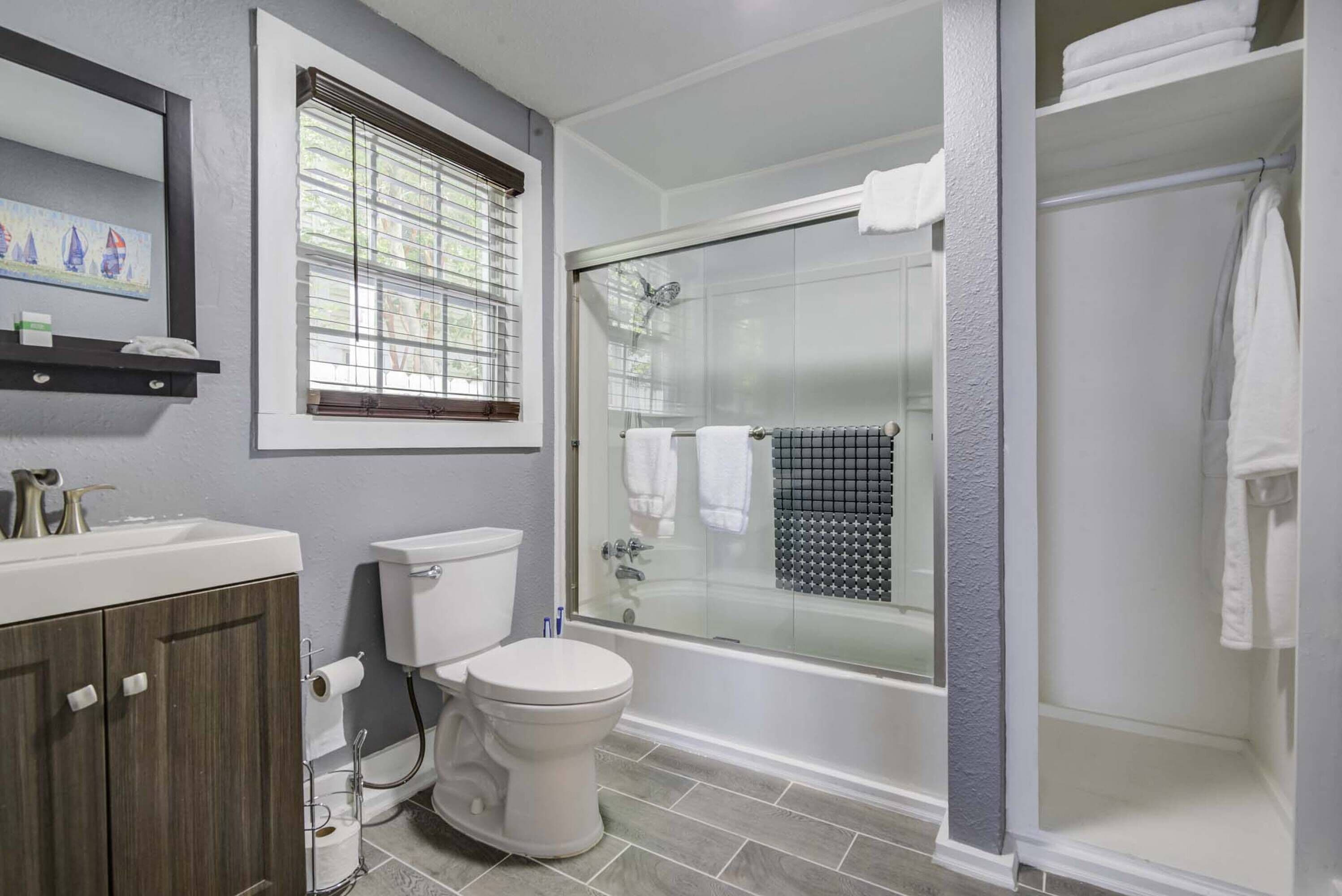A modern bathroom with a toilet, sink, and shower area.