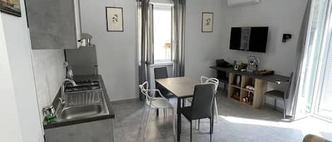 A compact living space with a kitchenette, dining area, and seating area.