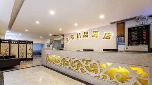A hotel reception area with a modern design, featuring a reception desk with illuminated signage and a decorative wall panel. - City Boutique Hotel (Heshan Zhongshan Road Xintiandi Branch) (Heshan)
