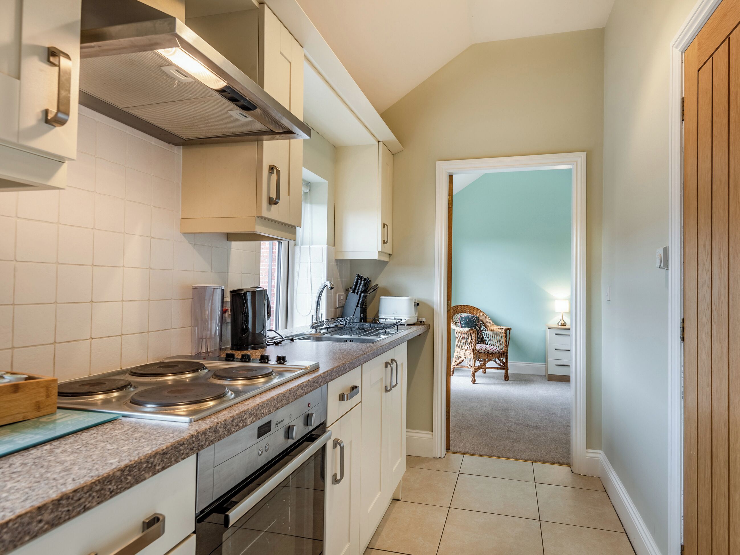 A kitchen with white cabinets, a stainless steel stove, and a window.