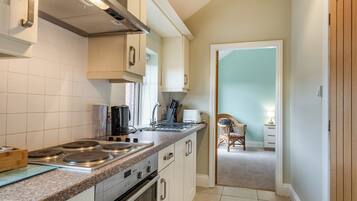 A kitchen with white cabinets, a stainless steel stove, and a window.